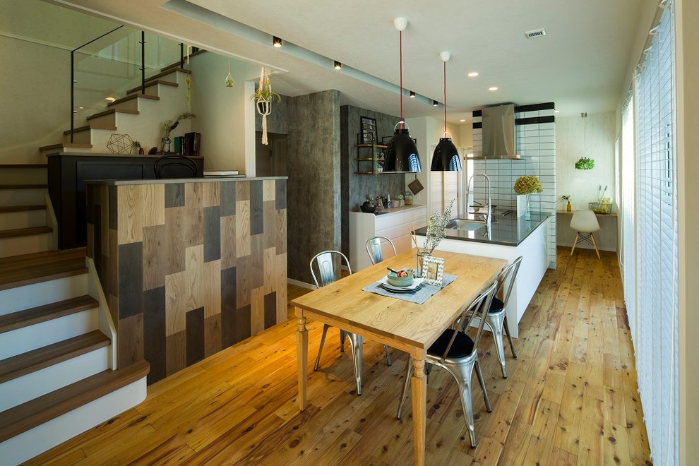 Cette photo montre une salle à manger asiatique avec un mur blanc, un sol en bois brun et un sol marron.