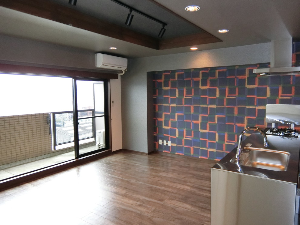 Réalisation d'une salle à manger ouverte sur le salon asiatique avec un mur multicolore et un sol en contreplaqué.