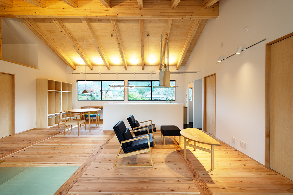 Aménagement d'un grand salon scandinave ouvert avec un sol de tatami, un poêle à bois, un manteau de cheminée en béton, un mur blanc, un téléviseur indépendant, un sol gris, poutres apparentes et du papier peint.