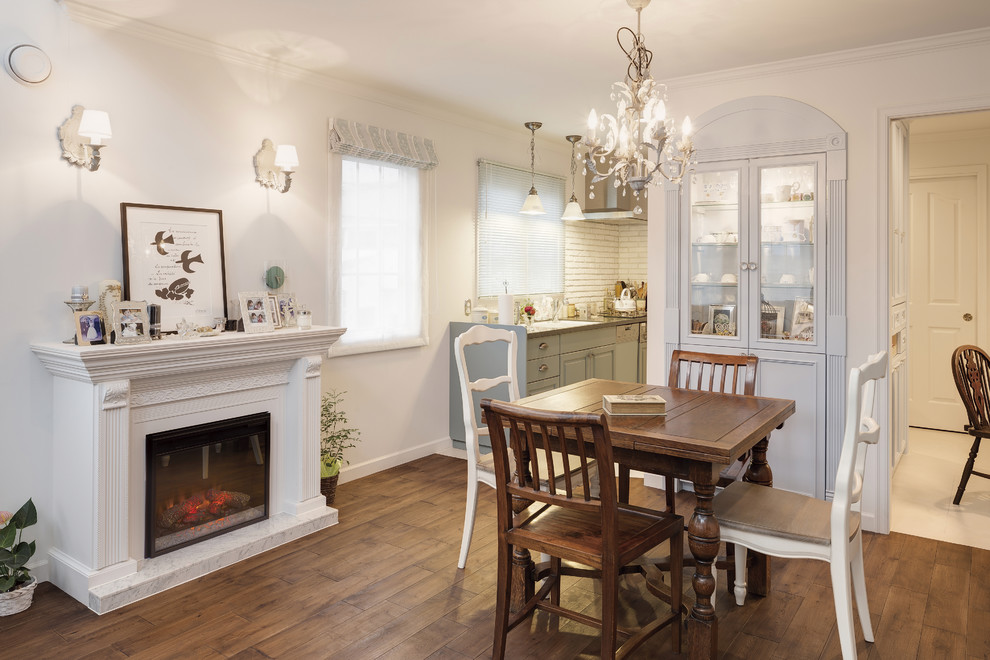 Traditional dining room in Other with white walls, medium hardwood flooring, a standard fireplace, a stone fireplace surround and brown floors.
