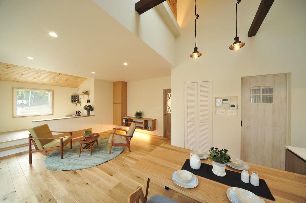 Modernes Esszimmer mit weißer Wandfarbe, hellem Holzboden und braunem Boden in Sonstige