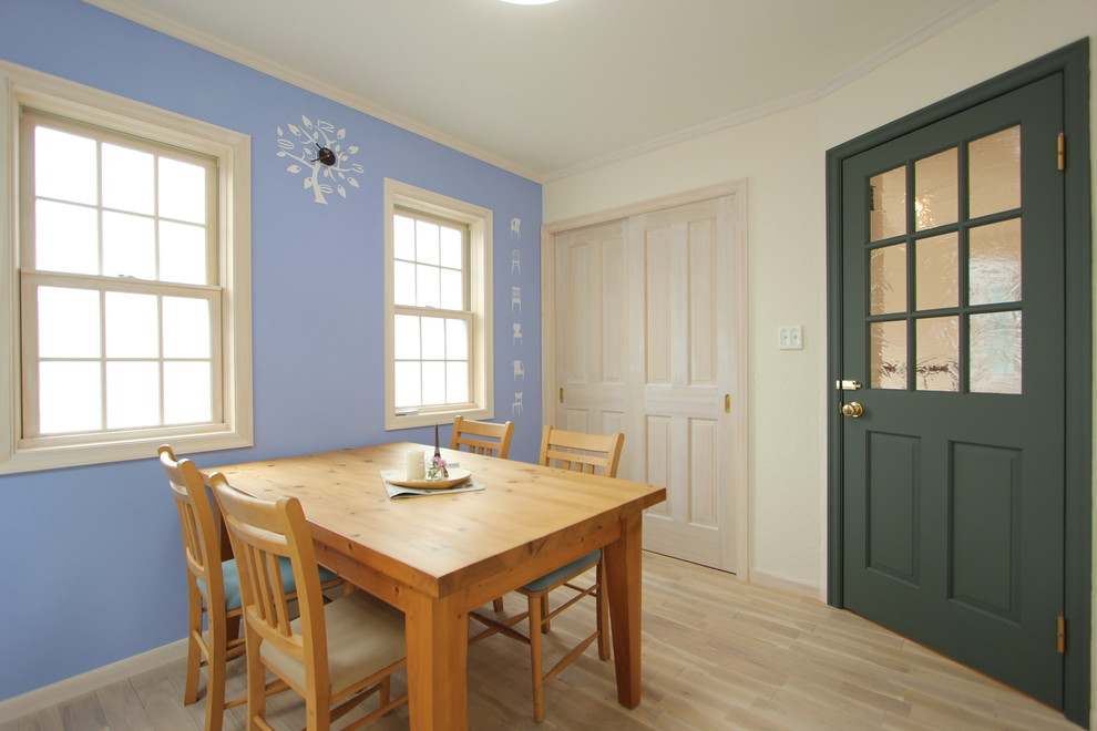 Immagine di una sala da pranzo scandinava con pareti blu e parquet chiaro