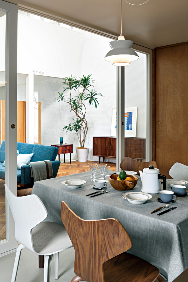Immagine di una sala da pranzo aperta verso il soggiorno scandinava con pareti bianche