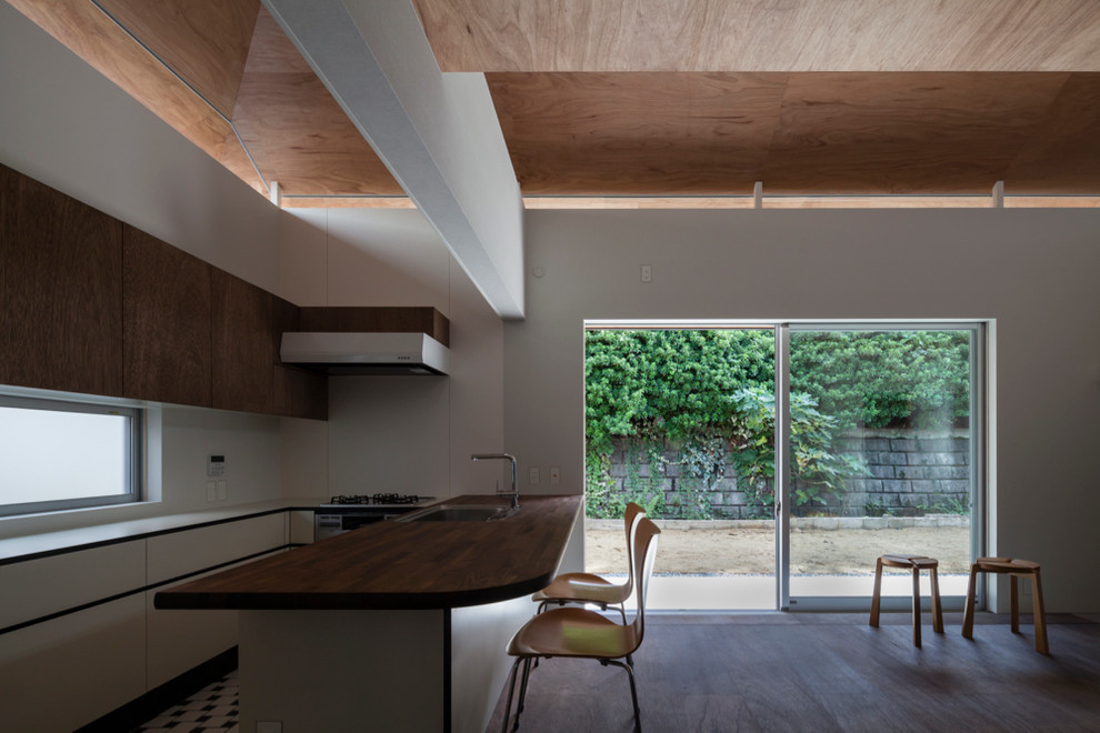 Inspiration pour une petite salle à manger ouverte sur le salon minimaliste avec un mur blanc, un sol en contreplaqué, aucune cheminée et un sol marron.