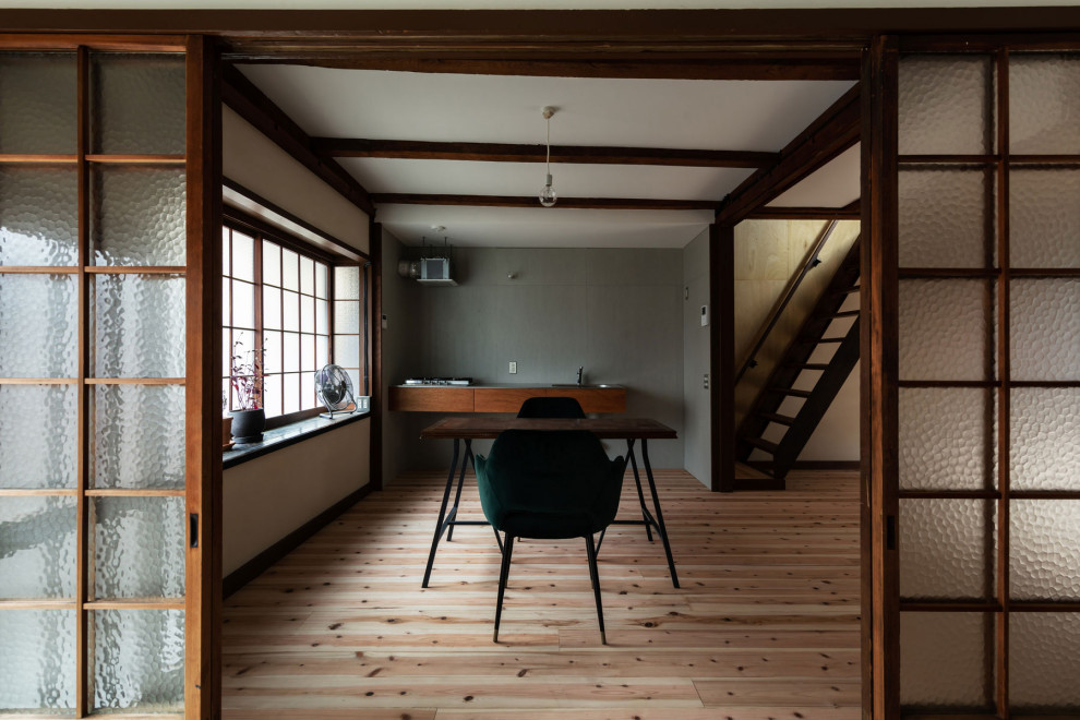Idee per una piccola sala da pranzo aperta verso il soggiorno chic con pareti bianche, parquet chiaro, pavimento beige, travi a vista e pareti in perlinato