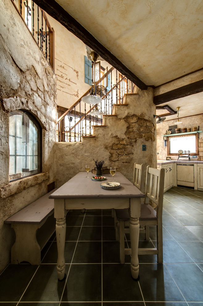 Cette image montre une salle à manger ouverte sur le salon traditionnelle avec un mur beige et un sol noir.