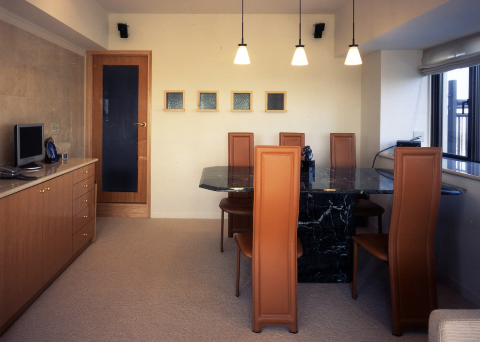 Cette photo montre une salle à manger ouverte sur la cuisine tendance de taille moyenne avec un mur blanc, un sol en liège, une cheminée ribbon et un manteau de cheminée en pierre.
