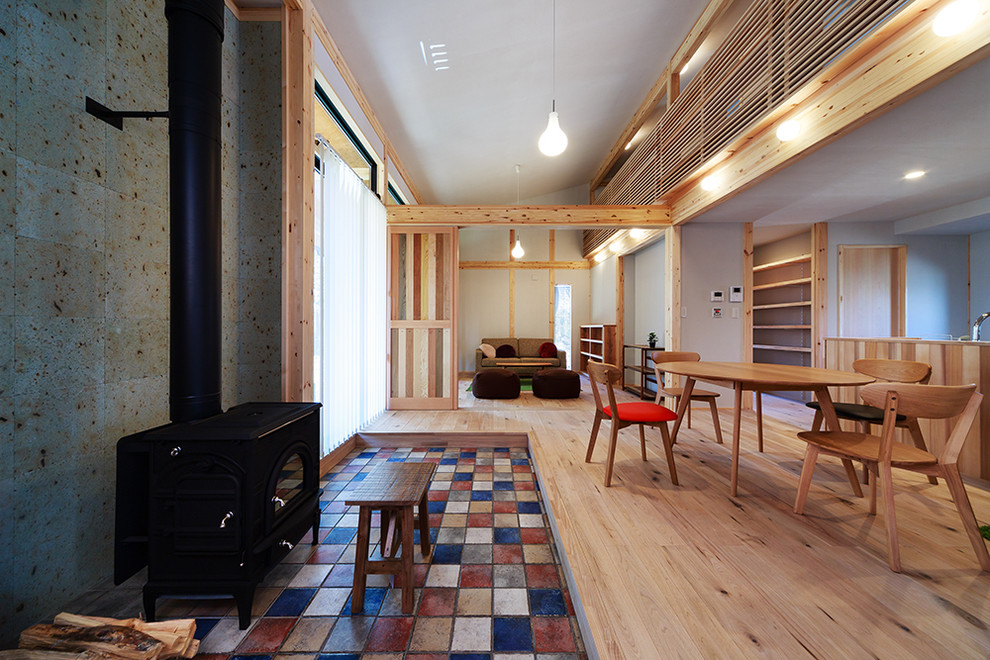 На фото: гостиная-столовая среднего размера в современном стиле с серыми стенами, светлым паркетным полом и печью-буржуйкой с