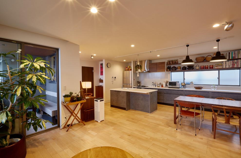 Esempio di una sala da pranzo aperta verso il soggiorno contemporanea con parquet chiaro, pavimento beige e pareti bianche