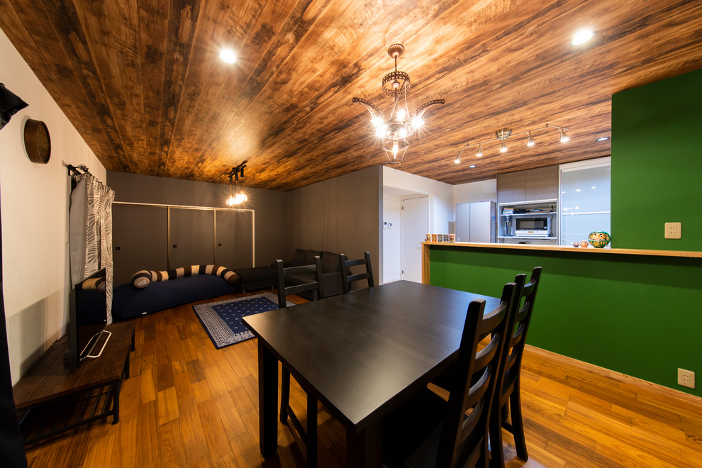 Idées déco pour une salle à manger ouverte sur le salon contemporaine de taille moyenne avec un mur multicolore, un sol en bois brun et un sol marron.