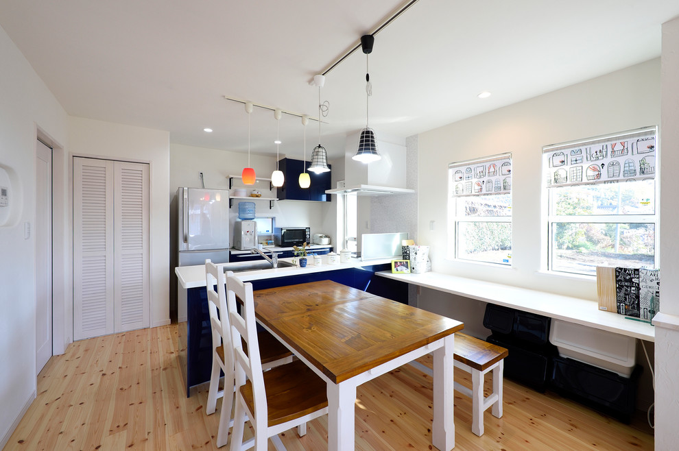 Exemple d'une salle à manger ouverte sur la cuisine scandinave avec un mur blanc, parquet clair et un sol beige.