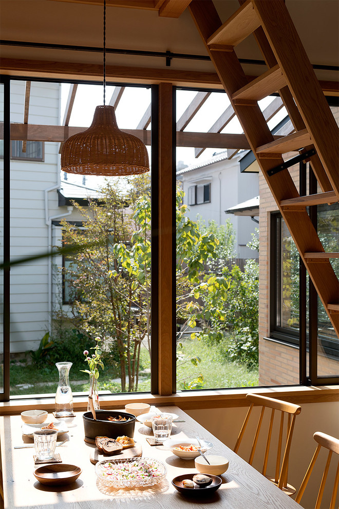 Idée de décoration pour une salle à manger ouverte sur le salon chalet avec un mur blanc et un sol en bois brun.