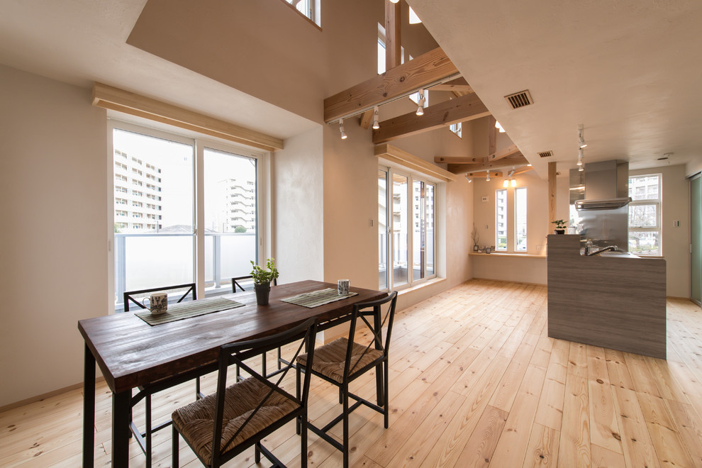 Idée de décoration pour une salle à manger ouverte sur le salon asiatique avec un mur blanc, parquet clair et un sol marron.