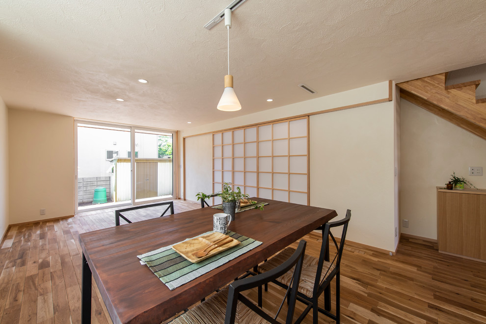 Offenes Asiatisches Esszimmer mit weißer Wandfarbe, braunem Holzboden und braunem Boden in Tokio Peripherie