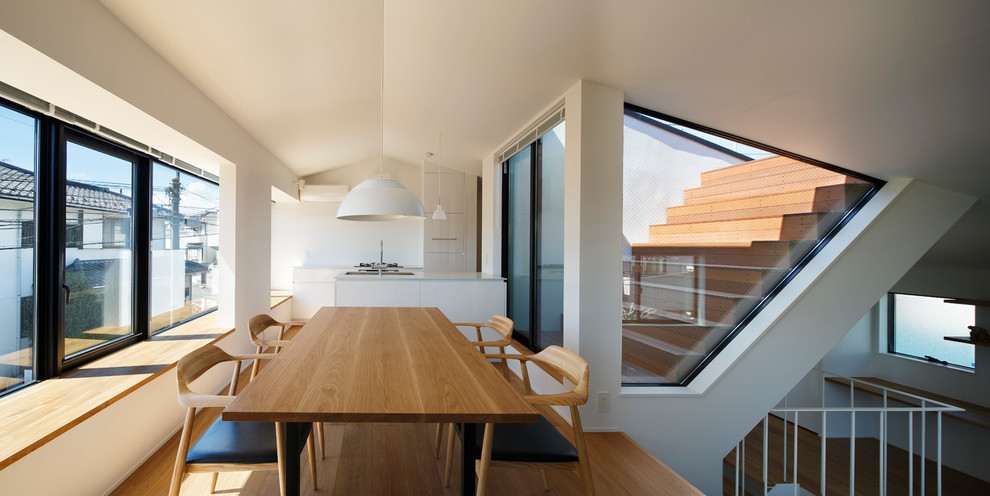 Идея дизайна: кухня-столовая среднего размера в скандинавском стиле с белыми стенами и паркетным полом среднего тона без камина