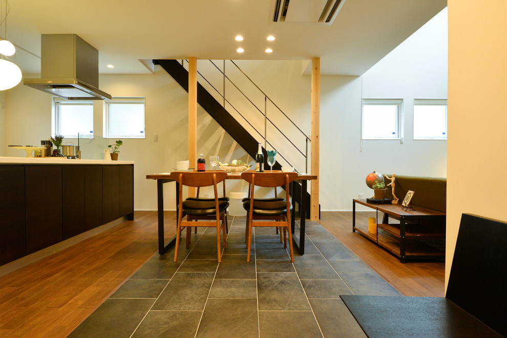 Ispirazione per una sala da pranzo aperta verso il soggiorno moderna con pareti bianche e pavimento multicolore