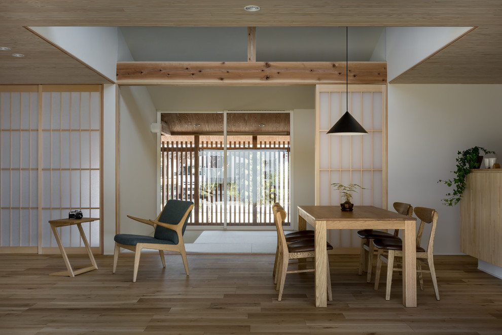Foto de comedor de estilo zen con paredes blancas, suelo de madera en tonos medios y suelo marrón