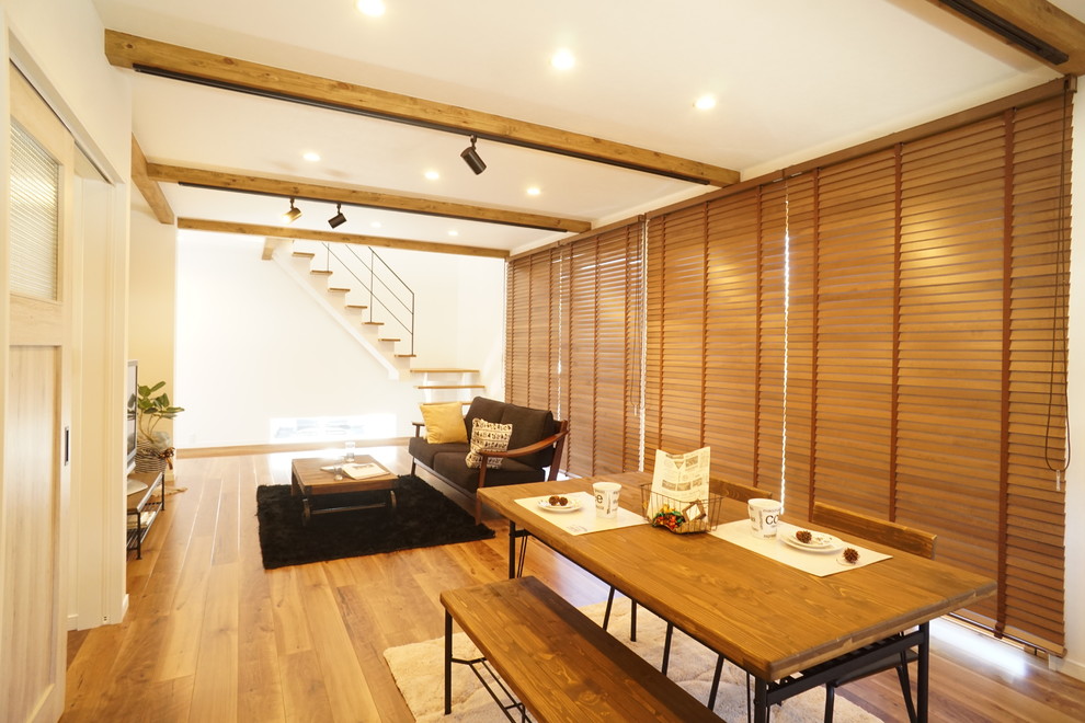 Idées déco pour une salle à manger ouverte sur le salon rétro avec un mur blanc, un sol en bois brun et un sol marron.