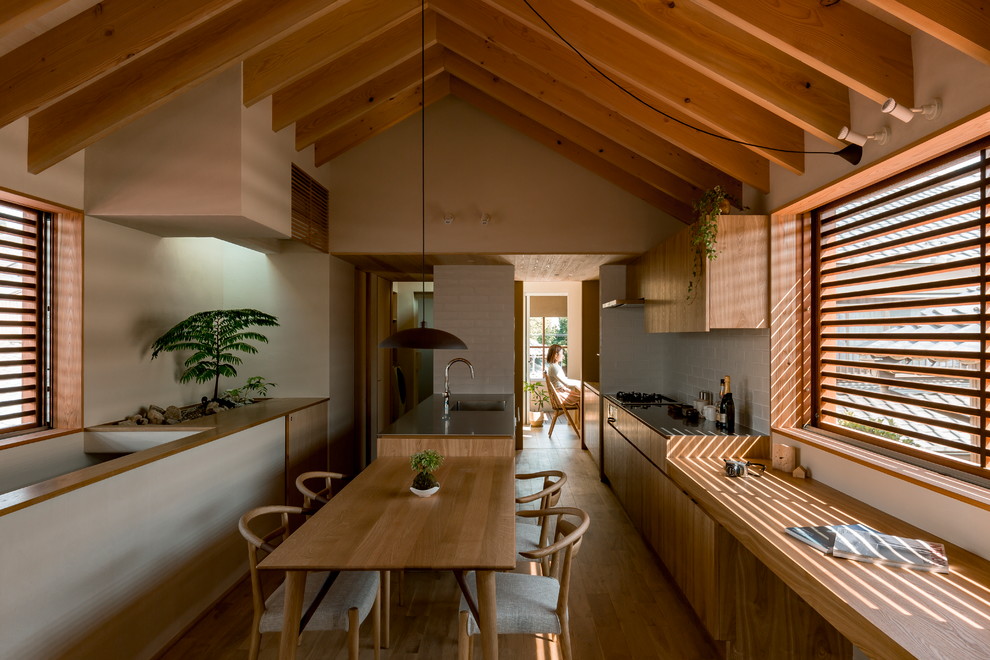Immagine di una sala da pranzo aperta verso il soggiorno etnica con pareti beige, pavimento in legno massello medio e pavimento marrone