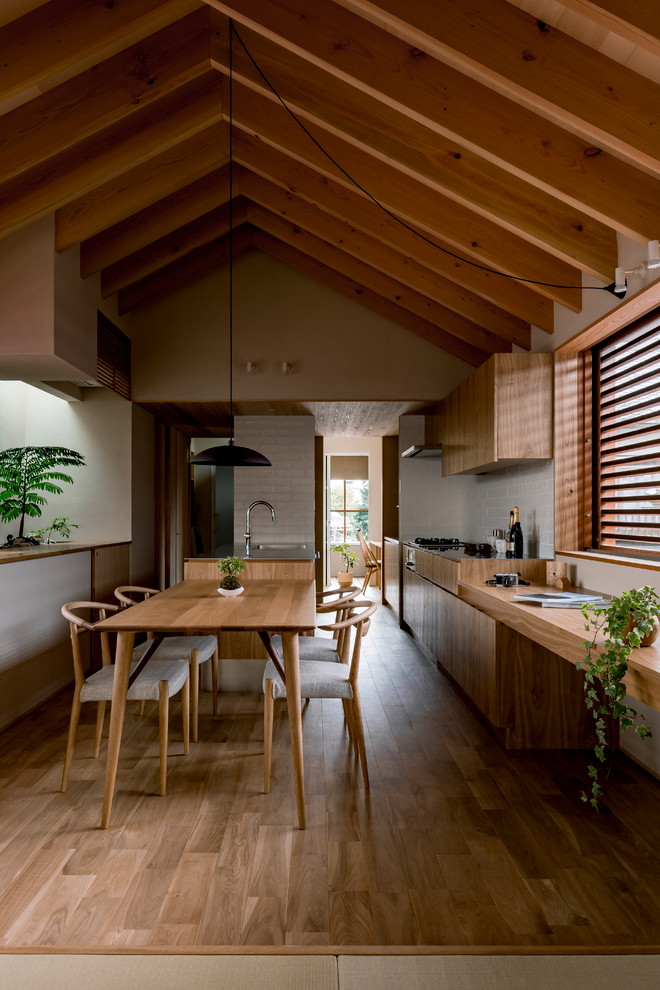Exemple d'une salle à manger asiatique avec un mur beige, un sol en bois brun et un sol marron.