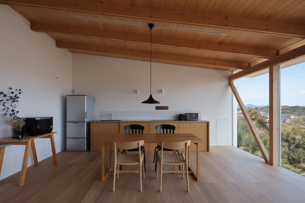 Ejemplo de comedor de cocina de estilo zen de tamaño medio con paredes blancas, suelo de madera en tonos medios, suelo marrón y madera