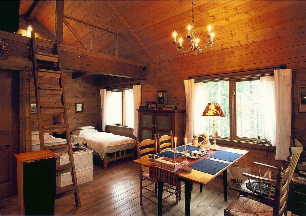 Foto di una piccola sala da pranzo aperta verso il soggiorno stile rurale con pavimento in legno massello medio, pareti marroni e nessun camino