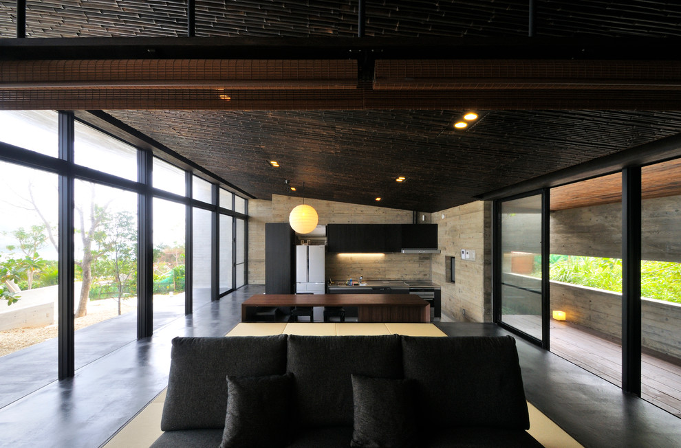 Esempio di una sala da pranzo aperta verso il soggiorno etnica con pareti grigie e pavimento in cemento
