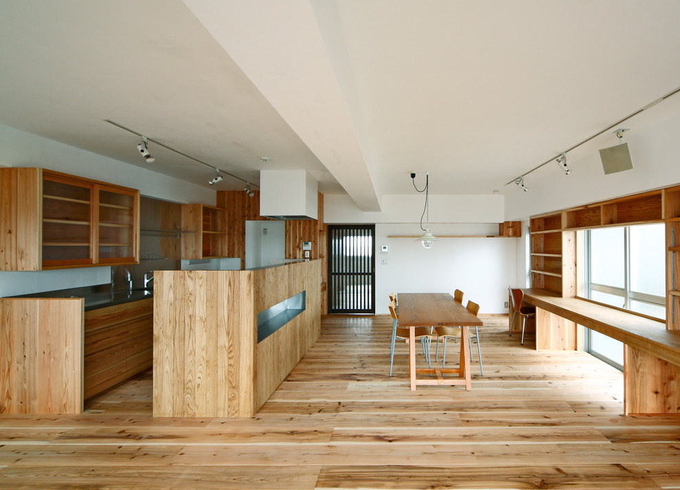 Offenes Rustikales Esszimmer mit weißer Wandfarbe, braunem Holzboden und braunem Boden in Osaka