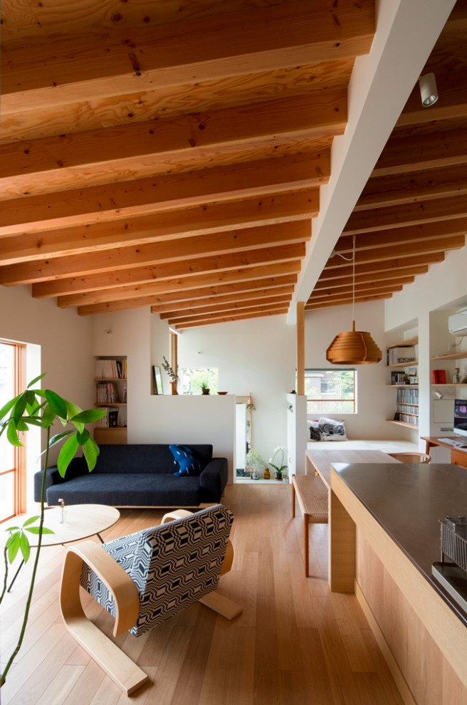 Foto di una piccola sala da pranzo aperta verso il soggiorno nordica con pareti bianche, pavimento in legno massello medio, pavimento marrone e travi a vista