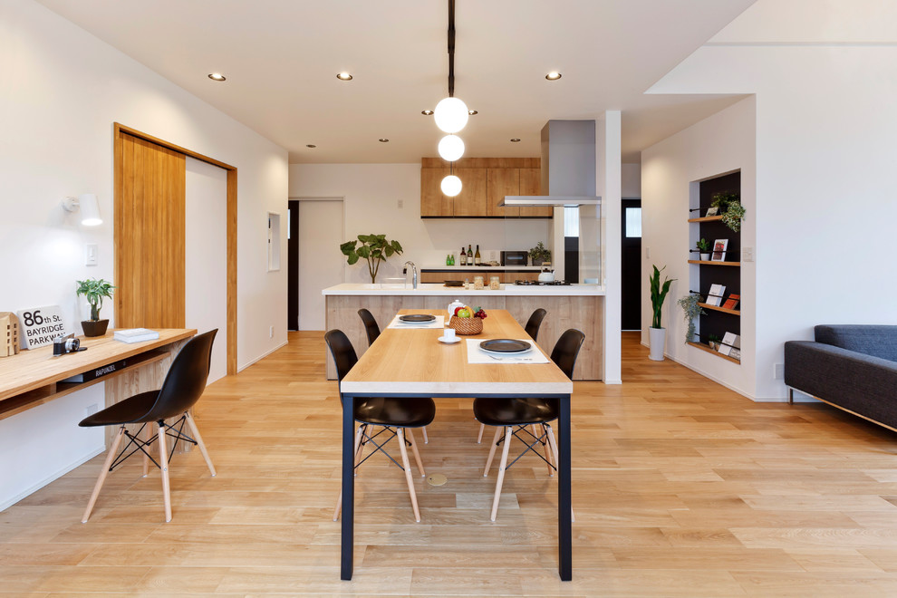Foto di una sala da pranzo aperta verso il soggiorno design con pareti bianche, pavimento in legno massello medio e pavimento marrone