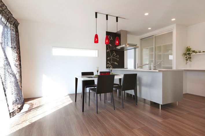 Idee per una sala da pranzo aperta verso il soggiorno minimalista di medie dimensioni con pareti bianche, pavimento in compensato e pavimento beige