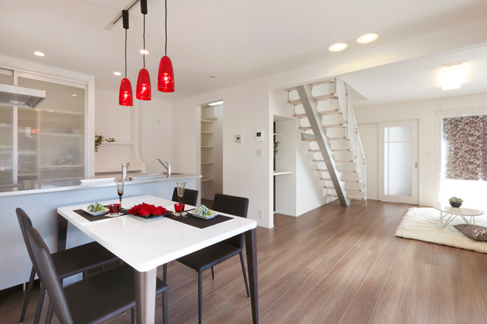 Esempio di una sala da pranzo aperta verso il soggiorno minimalista di medie dimensioni con pareti bianche, pavimento in compensato e pavimento beige