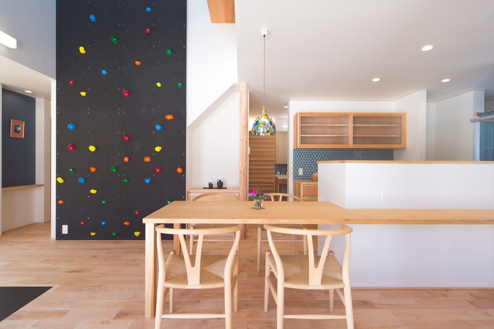 Immagine di una sala da pranzo aperta verso la cucina design con pareti bianche, parquet chiaro e pavimento beige