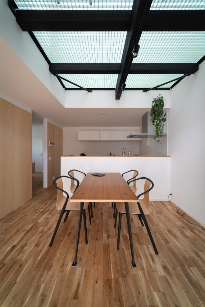 Idéer för mellanstora industriella kök med matplatser, med vita väggar, ljust trägolv och brunt golv