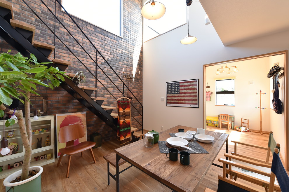 Cette image montre une salle à manger ouverte sur le salon urbaine avec un mur blanc, un sol en bois brun et un sol marron.