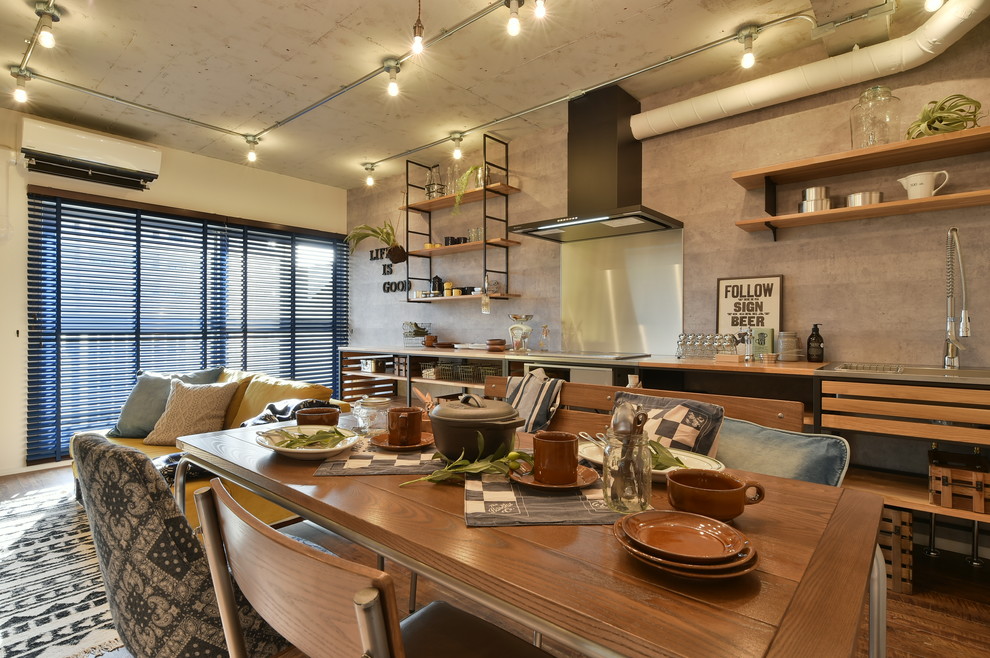 Aménagement d'une salle à manger industrielle avec un mur gris, un sol en bois brun et un sol marron.