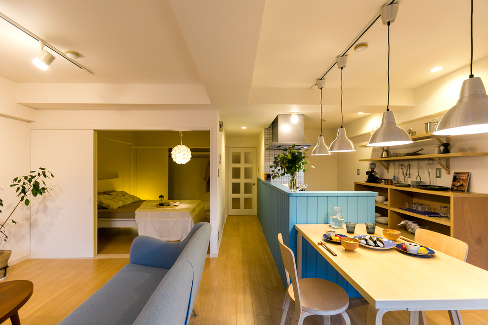 Exemple d'une salle à manger scandinave avec un mur blanc, un sol en bois brun et un sol marron.