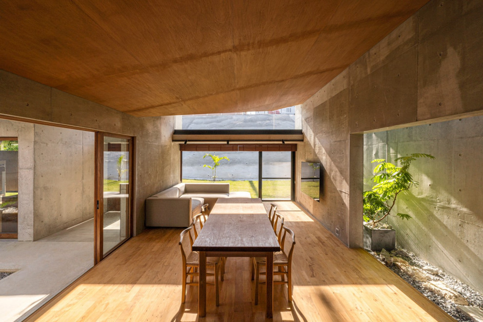 Exemple d'une salle à manger ouverte sur le salon asiatique de taille moyenne avec un mur gris, un sol en bois brun, aucune cheminée et un sol beige.