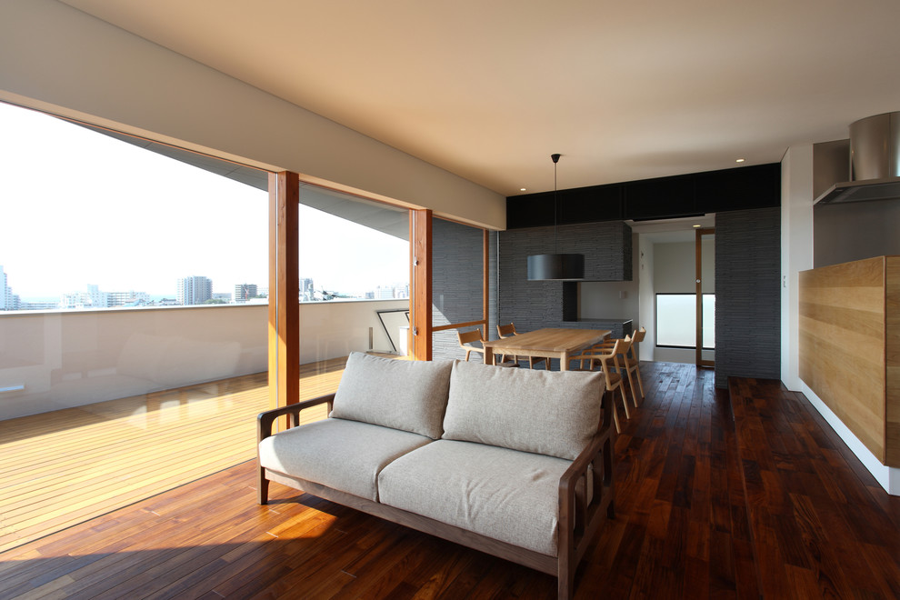 Стильный дизайн: большая открытая гостиная комната в стиле модернизм с коричневым полом, белыми стенами, темным паркетным полом, отдельно стоящим телевизором, потолком с обоями и обоями на стенах - последний тренд