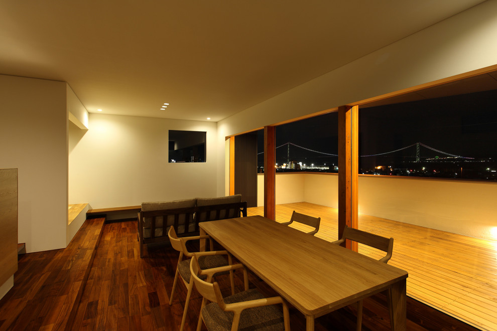 Idee per una grande sala da pranzo aperta verso il soggiorno minimalista con pareti beige, parquet scuro e pavimento marrone