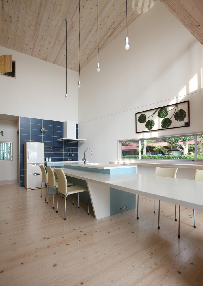 Diseño de comedor contemporáneo abierto con paredes blancas, suelo de madera clara y suelo beige