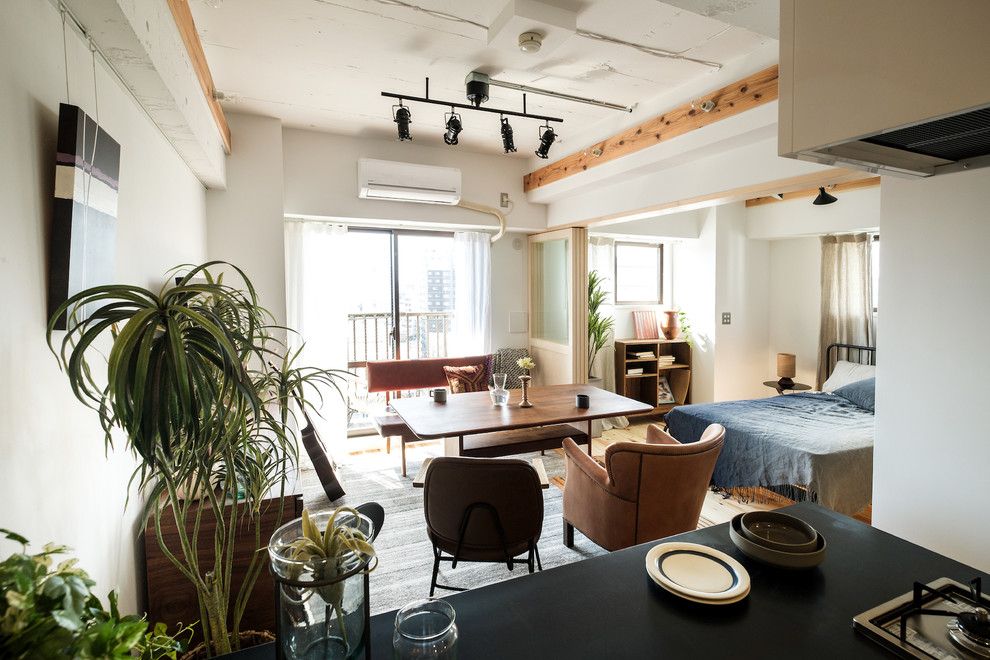 Ispirazione per una piccola sala da pranzo aperta verso il soggiorno industriale con pareti bianche e pavimento marrone