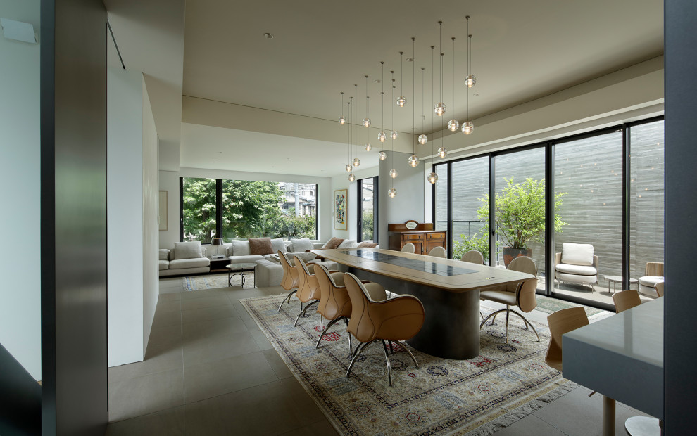 Immagine di una grande sala da pranzo aperta verso il soggiorno moderna con pareti bianche, pavimento con piastrelle in ceramica, pavimento grigio e soffitto ribassato