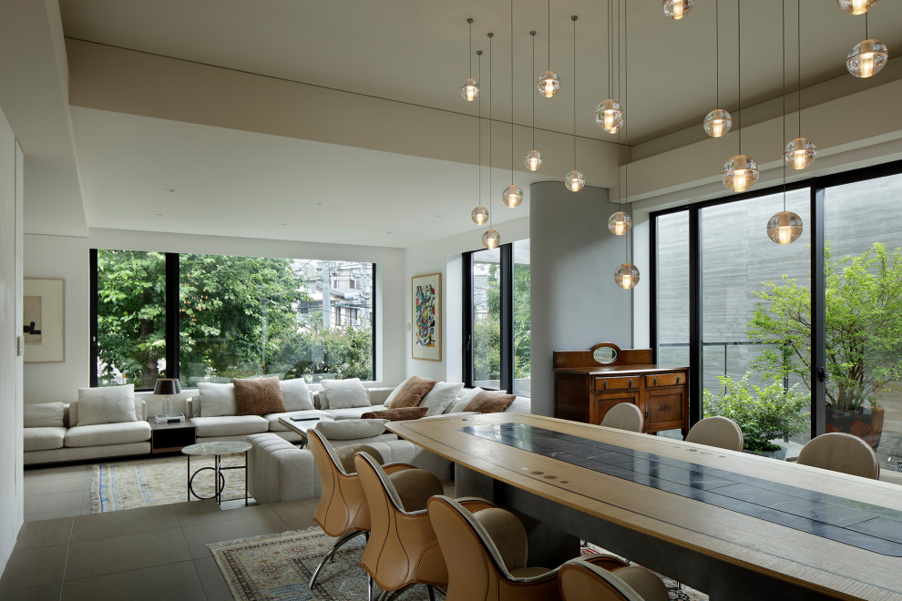 На фото: большая гостиная-столовая в стиле модернизм с белыми стенами, полом из керамической плитки, серым полом и многоуровневым потолком с