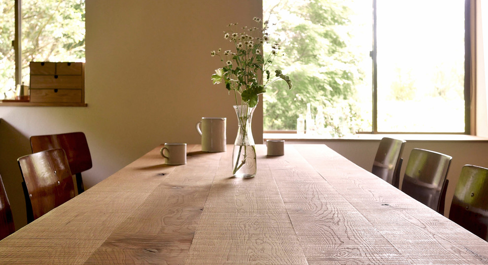 Foto di una sala da pranzo aperta verso la cucina moderna con pareti bianche e parquet chiaro