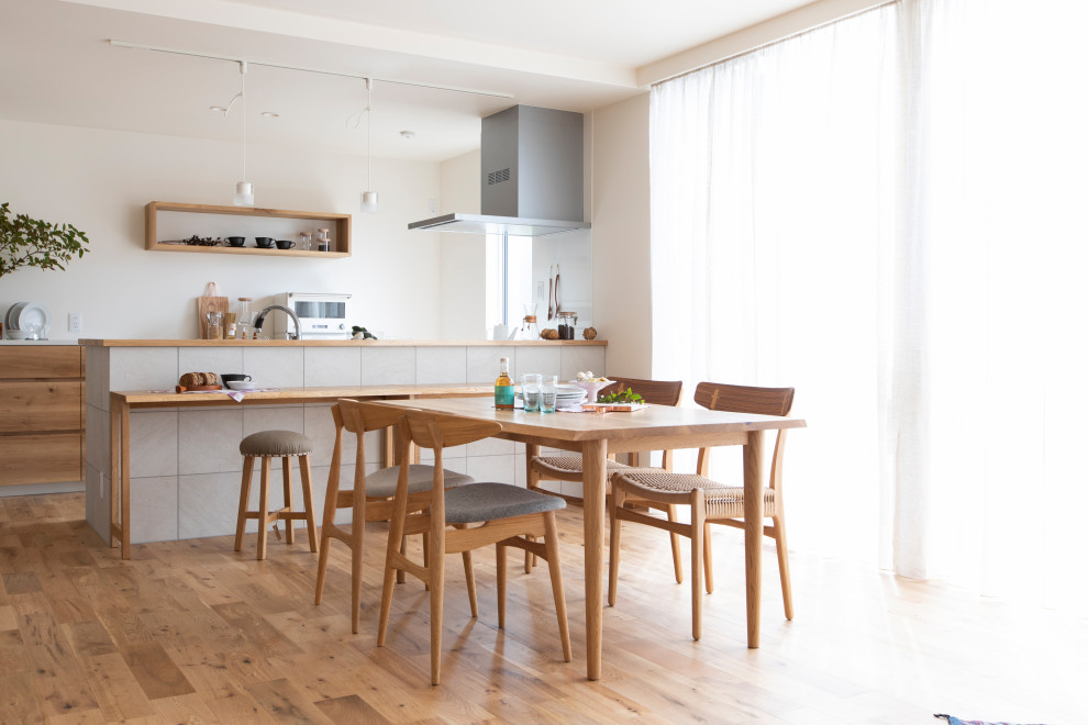 Idées déco pour une salle à manger ouverte sur la cuisine asiatique de taille moyenne avec un mur blanc, un sol en bois brun et un sol beige.