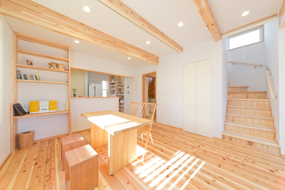 Idee per una sala da pranzo aperta verso il soggiorno country con pareti bianche, parquet chiaro e pavimento beige
