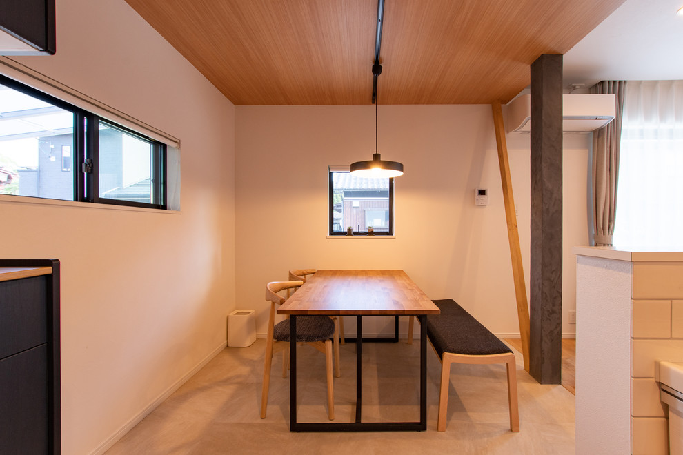 Bild på en minimalistisk matplats med öppen planlösning, med vita väggar och beiget golv