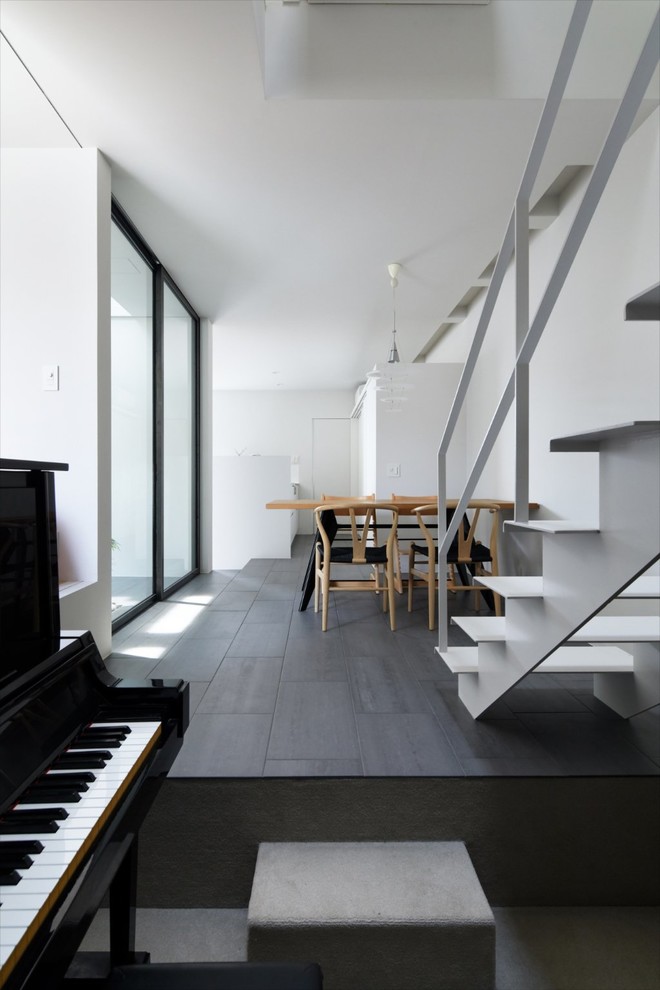 Idee per una piccola sala da pranzo aperta verso il soggiorno contemporanea con pareti bianche e pavimento grigio