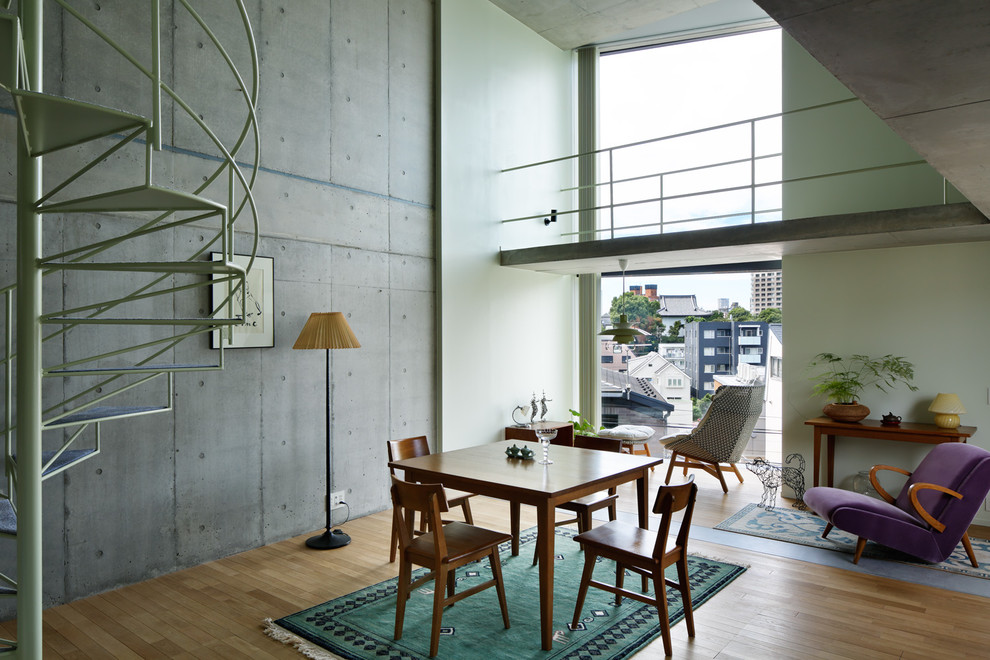 Photo of an industrial dining room in Tokyo with grey walls, light hardwood flooring and grey floors.